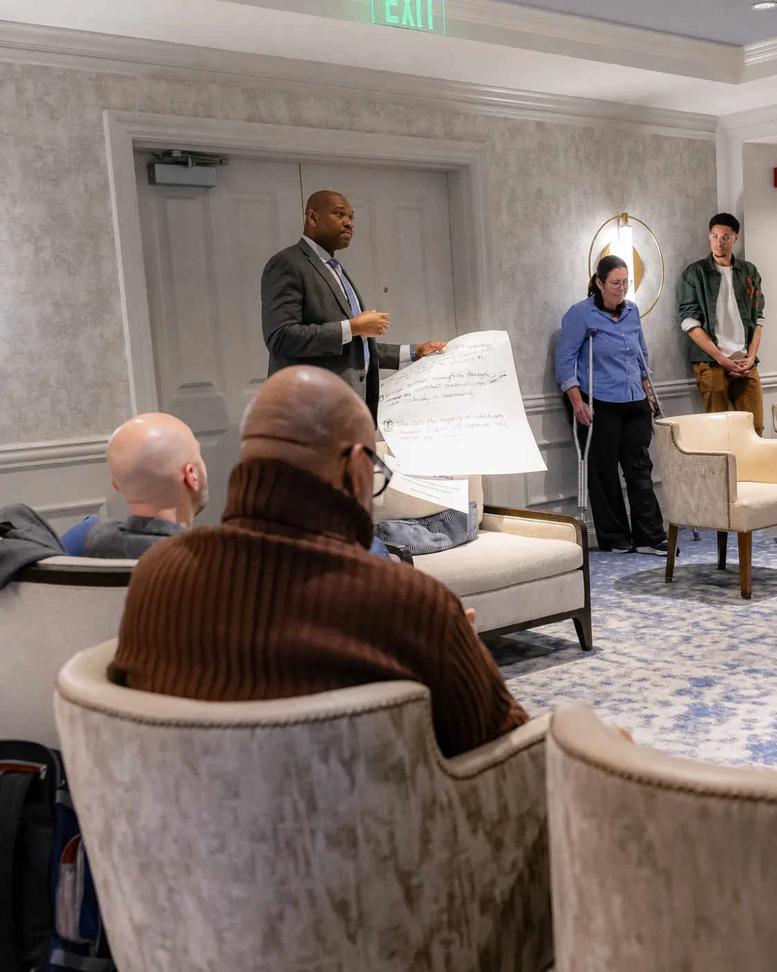 Dr Banda Khalifa explaining a workshop exercise while holding a working sheet